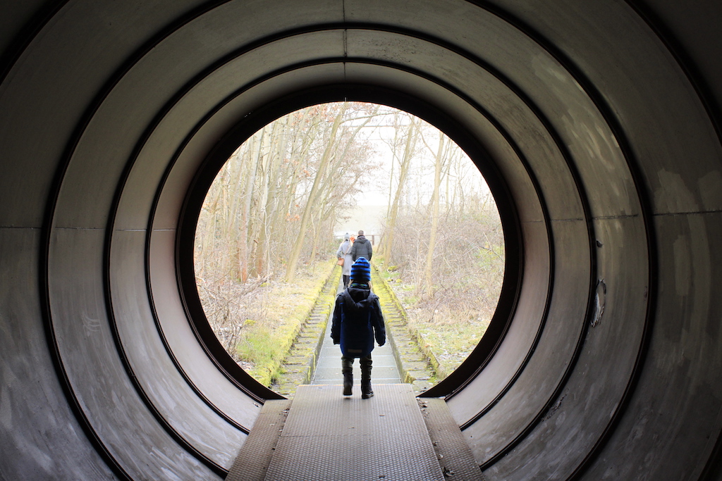 Kind steht am Ausgang eines Tunnels